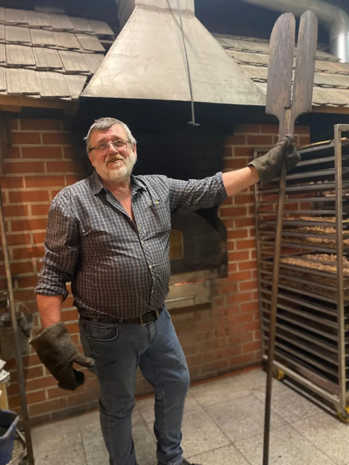 Der Leinerbauer mit Ofenschieber vor dem gemauerten Holzbackofen