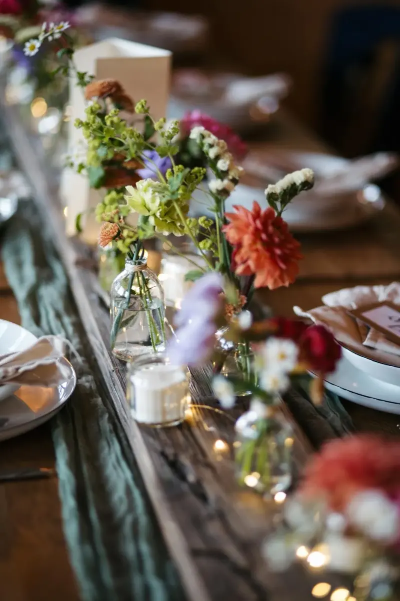 Sommerblumen und Kerzen auf der Holztafel